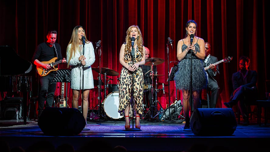 A lively performance at the Apollo Theatre, featuring a diverse audience and vibrant stage lighting.