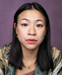 Nathania Ong smiling, with long dark hair and wearing a black top against a neutral background.