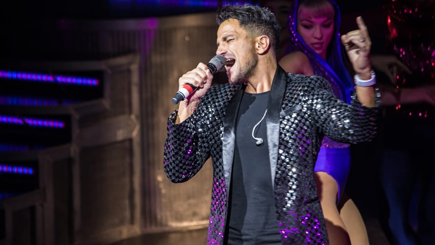Peter Andre performing on stage in a dynamic pose during Thriller Live at the Lyric Theatre.