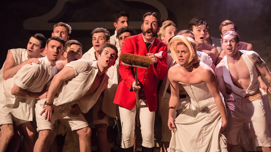 A theatrical scene featuring actors in pirate costumes performing on stage with dramatic lighting.