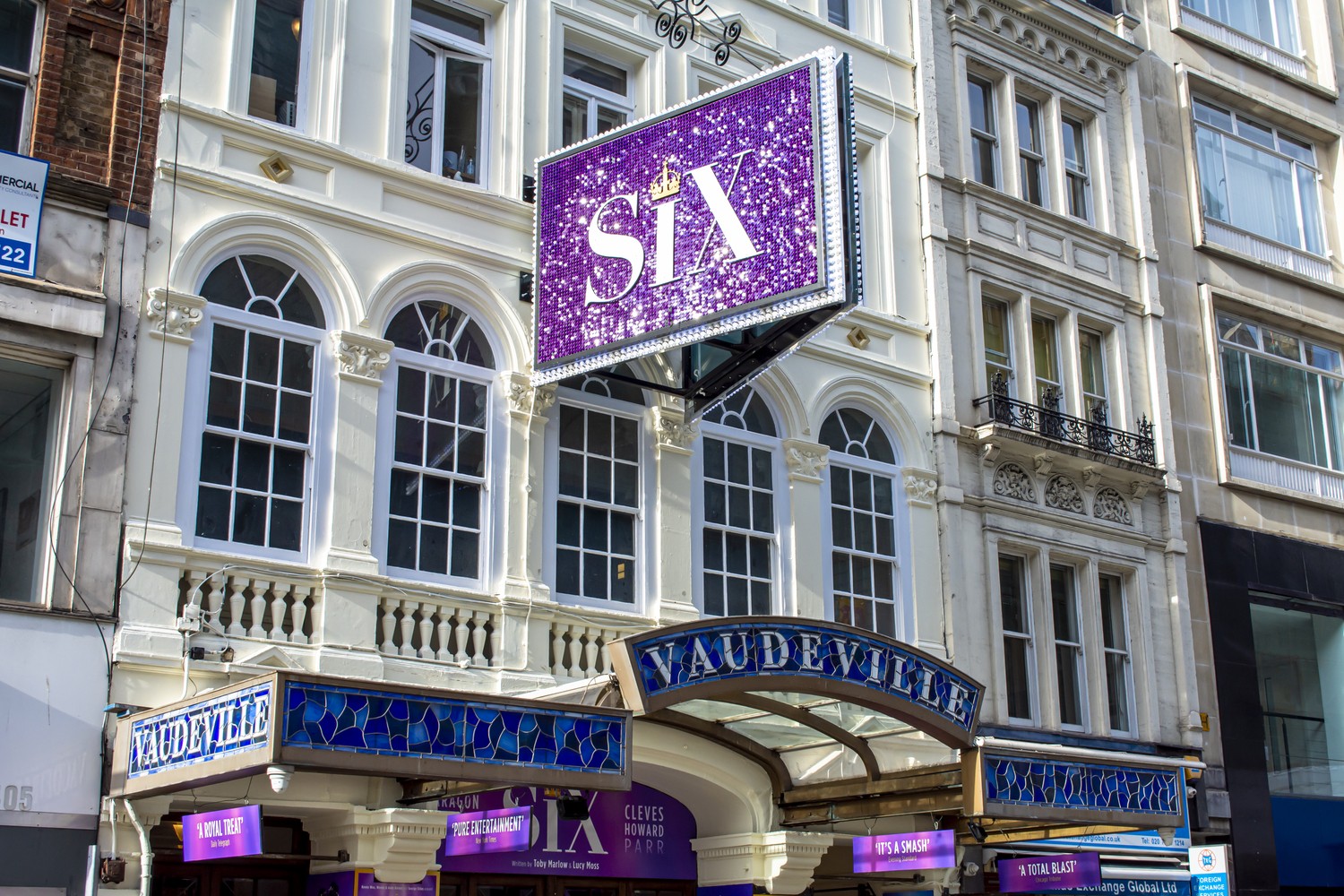 Exterior view of the Vaudeville Theatre, showcasing its ornate architecture and illuminated signage.