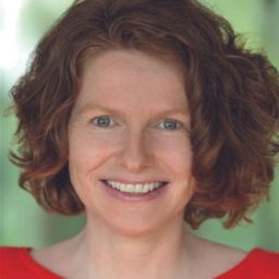 Headshot of Shelley Atkinson, featuring a smiling woman with shoulder-length brown hair and a blue blouse.