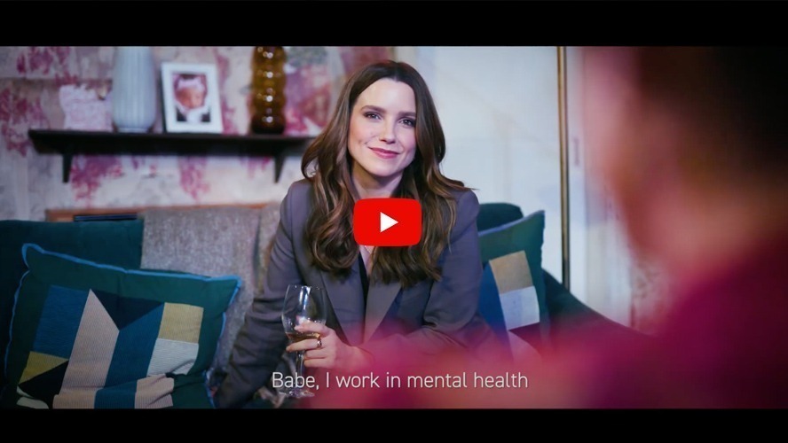 Sophia Bush on stage at the Apollo Theatre, wearing a stylish outfit and smiling.