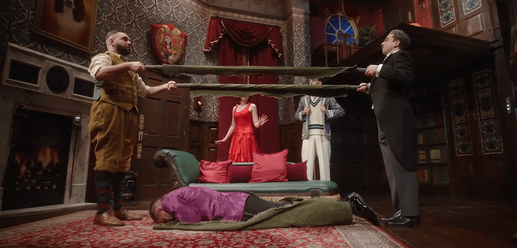 A chaotic scene from "The Play That Goes Wrong" featuring actors in disarray on stage.