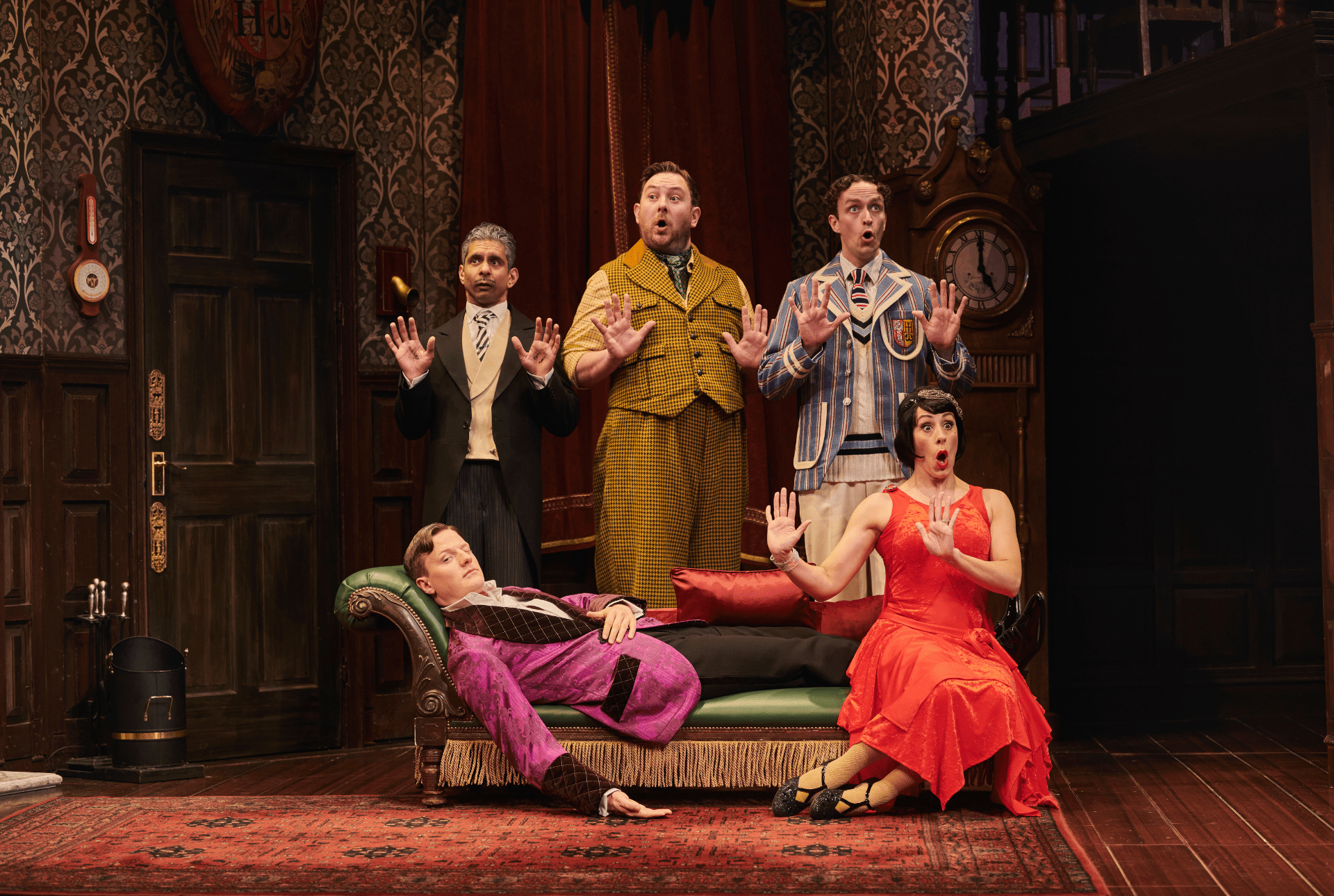 Matt Crockett, a photographer, stands in front of a backdrop featuring "The Play That Goes Wrong.