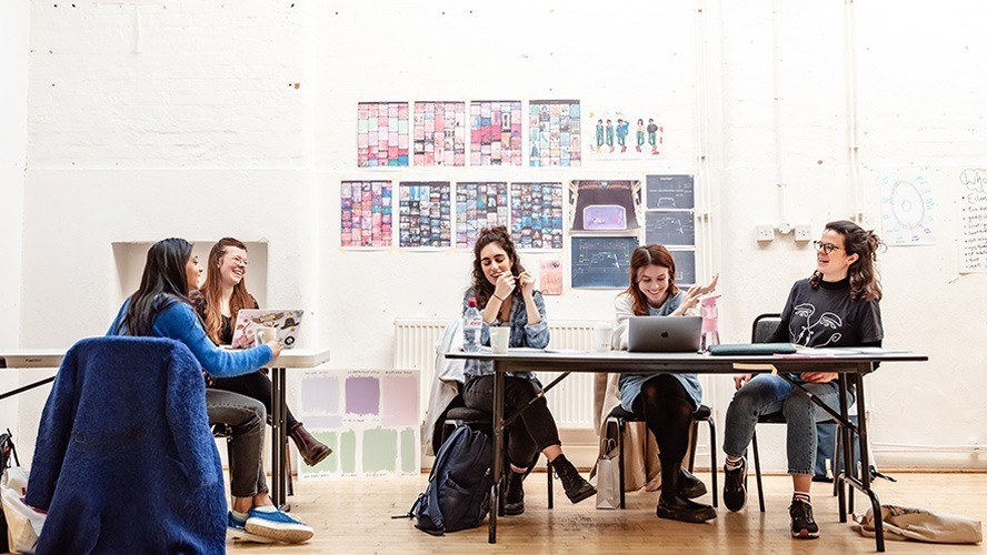 Teenagers rehearsing a dramatic scene on stage, with scripts and props scattered around.