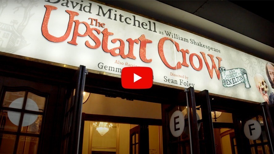 A vibrant still from "The Upstart Crow" featuring characters in Elizabethan costumes on stage.