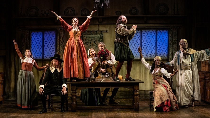 Cast members of "The Upstart Crow" at the Apollo Theatre, dressed in period costumes, smiling.