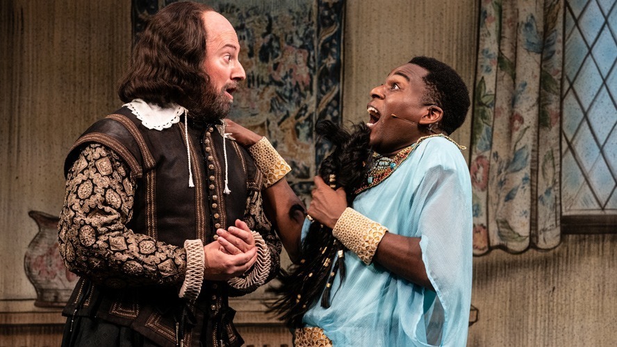 Five actors in period costumes pose together on stage at the Apollo Theatre.