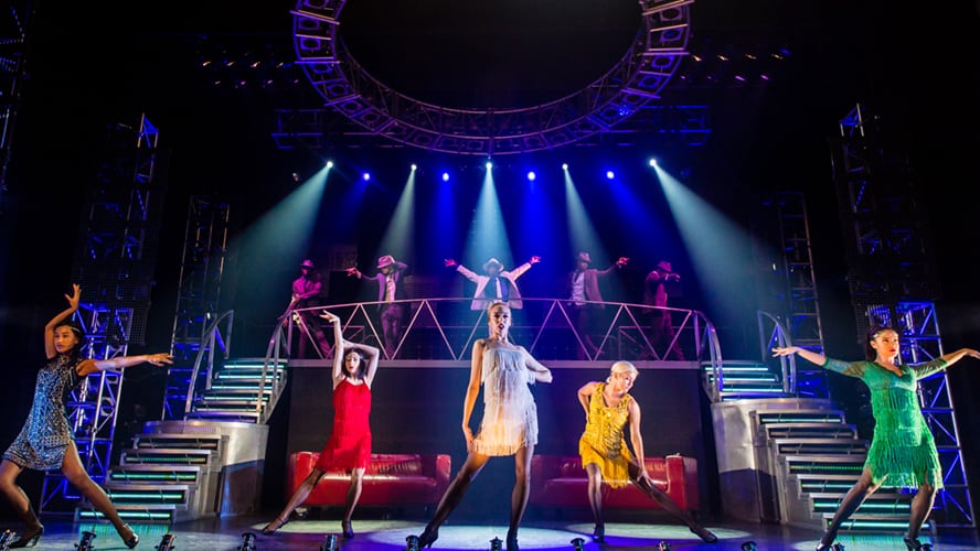 A vibrant stage scene from "Thriller Live," featuring dancers in dynamic poses and colourful costumes.