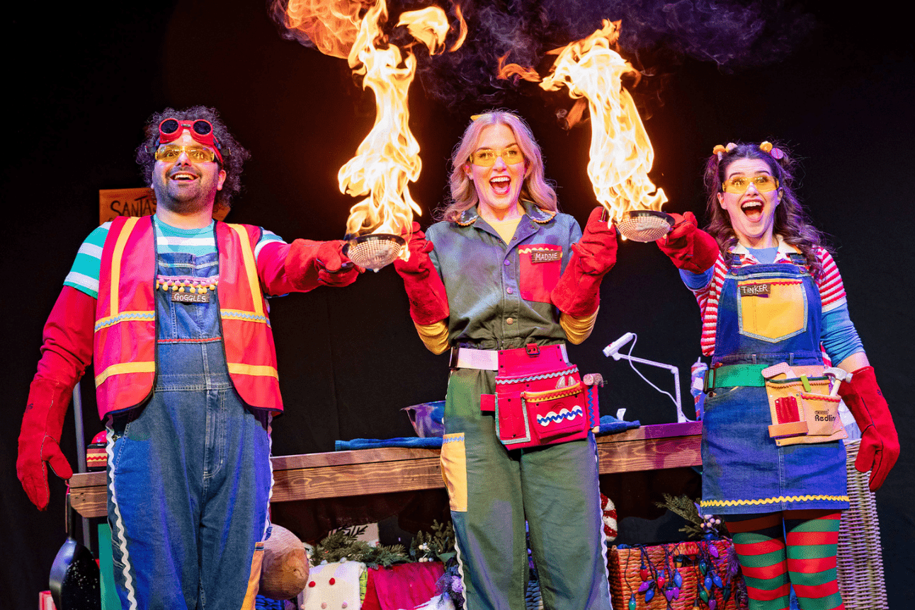 Maddie Moate surrounded by festive decorations and a glowing fireplace, smiling warmly.