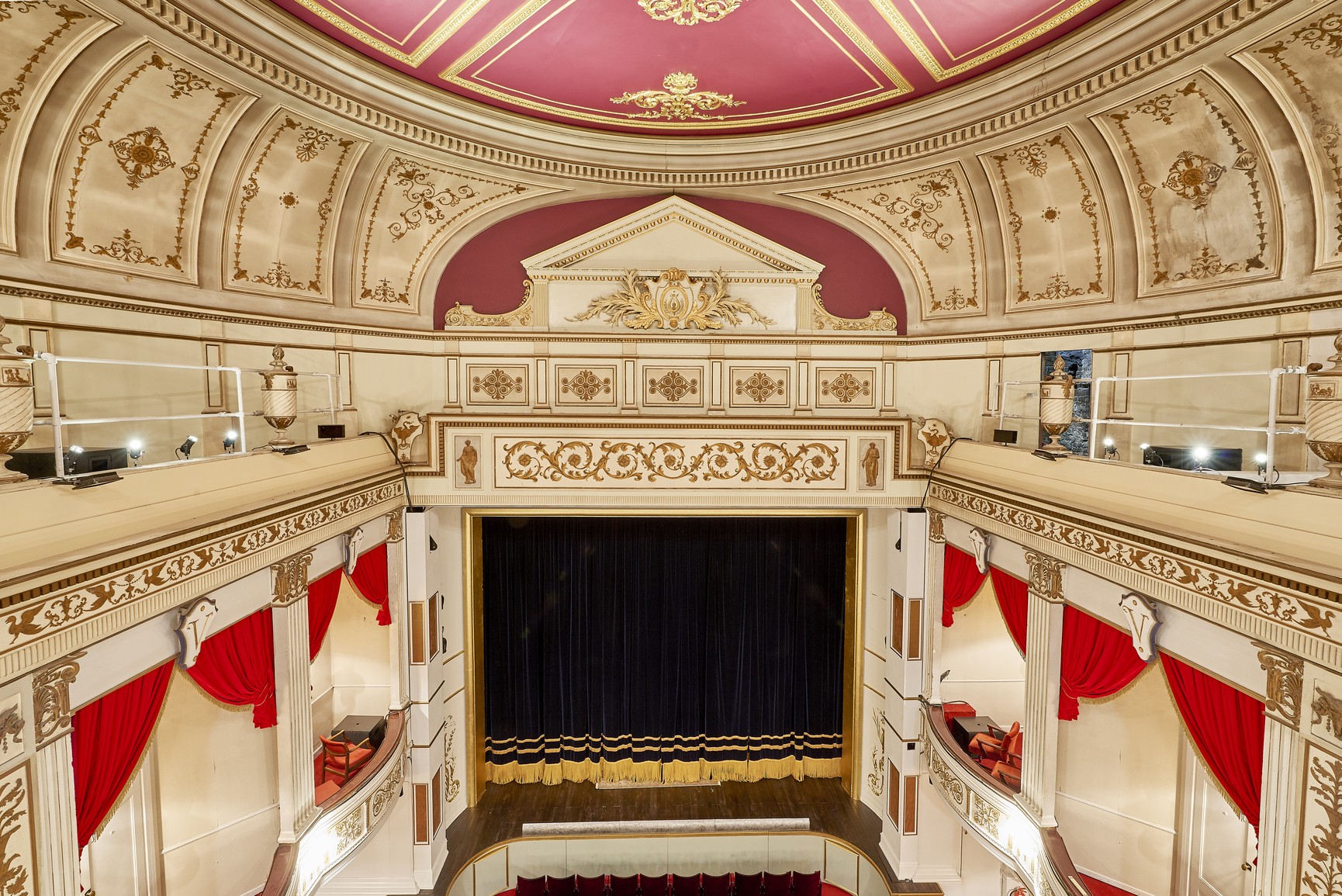 Exterior view of Vaudeville Theatre, featuring ornate architecture and a marquee displaying show titles.
