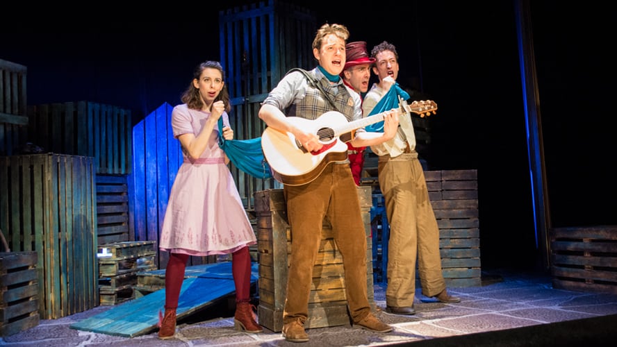 A vibrant stage scene with actors in elaborate costumes performing at the Vaudeville Theatre.