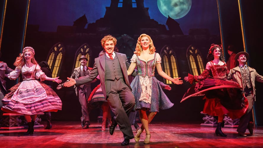 A scene from Young Frankenstein featuring actors in period costumes on a theatrical stage.