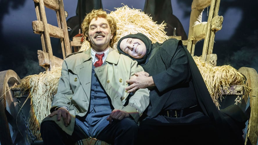 A scene from Young Frankenstein featuring characters in period costumes, with dramatic lighting and props.