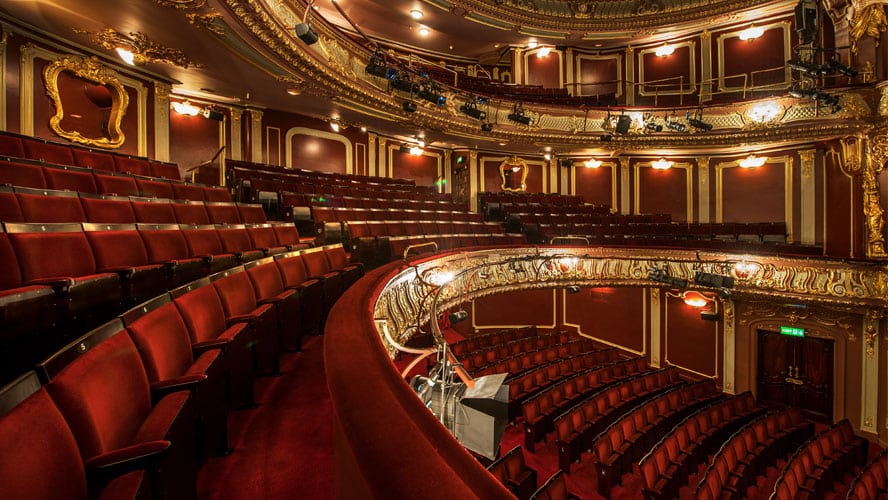 Interior of Apollo Theatre showcasing rich red velvet seating and intricate gold embellishments.