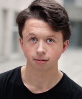 Richard Leeming poses for a professional headshot, wearing a dark suit and smiling confidently.