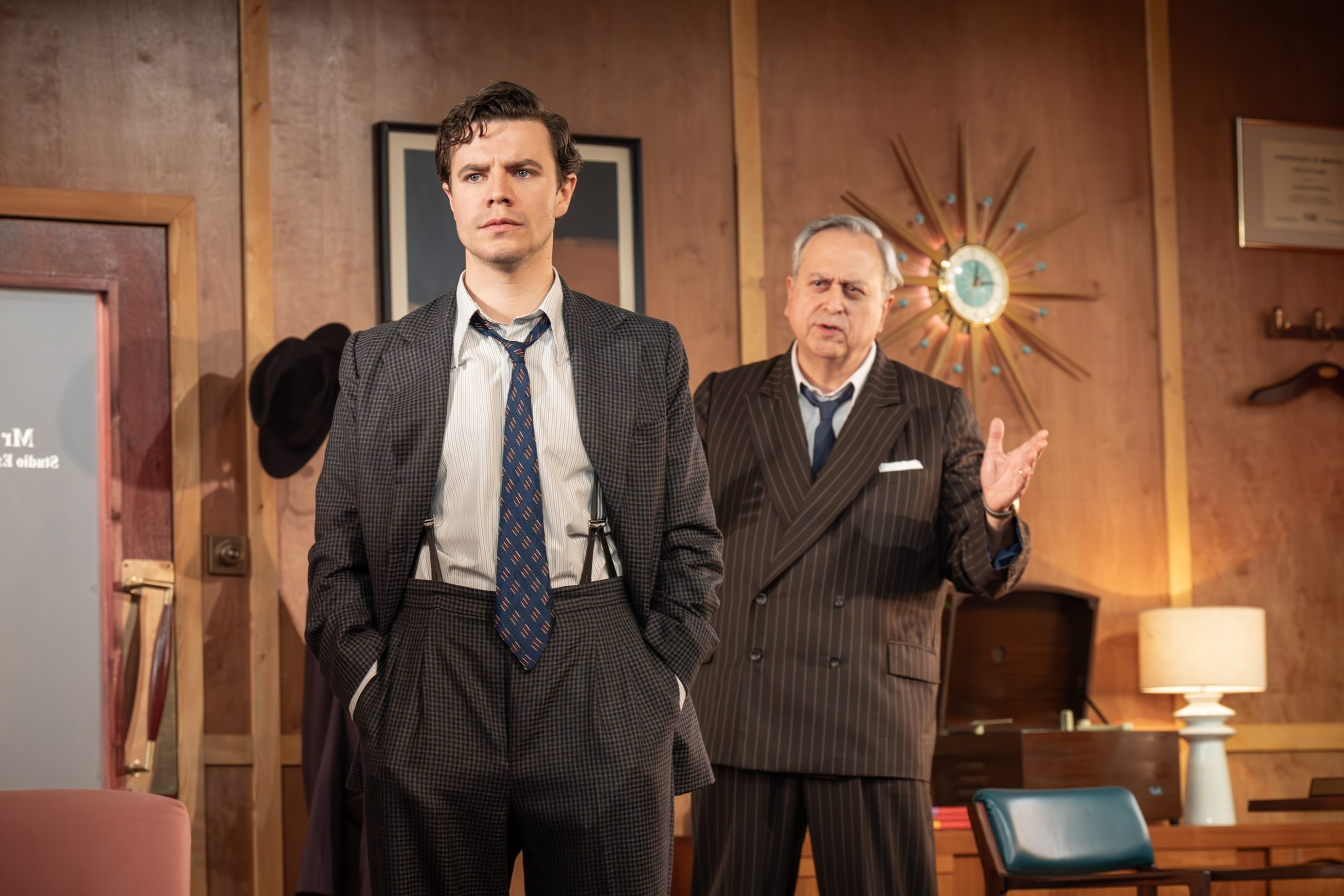 A vibrant theatre scene featuring actors on stage with dramatic lighting and a captivated audience.