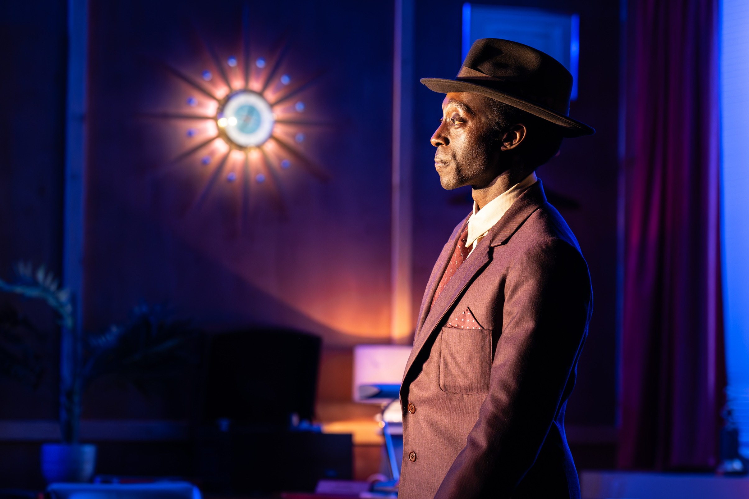A vibrant theatre scene featuring actors performing on stage with dramatic lighting and set design.