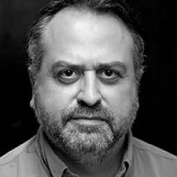 Stanley Townsend poses against a textured backdrop, wearing a dark jacket and looking thoughtfully off-camera.