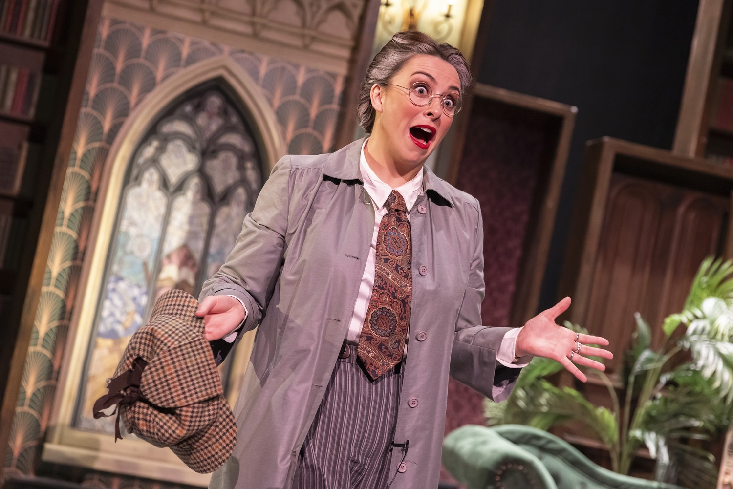A dramatic stage setup with props and lighting for "Murder, She Didn't Write" performance.
