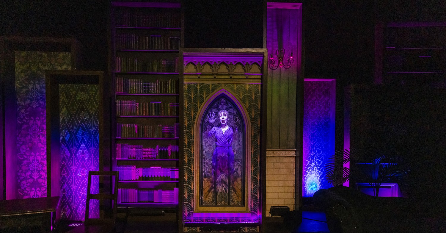 A dramatic stage setup with lighting and props for the production "Murder, She Didn't Write.