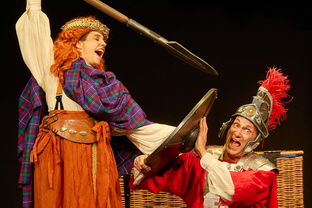 A vibrant scene from Horrible Histories: Barmy Britain featuring characters in historical costumes and props.