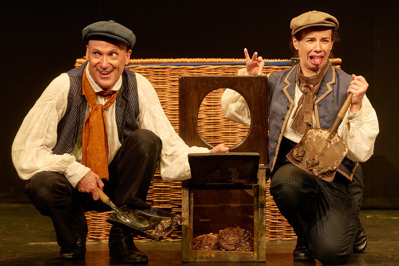 A vibrant scene from Horrible Histories: Barmy Britain featuring characters in historical costumes and props.