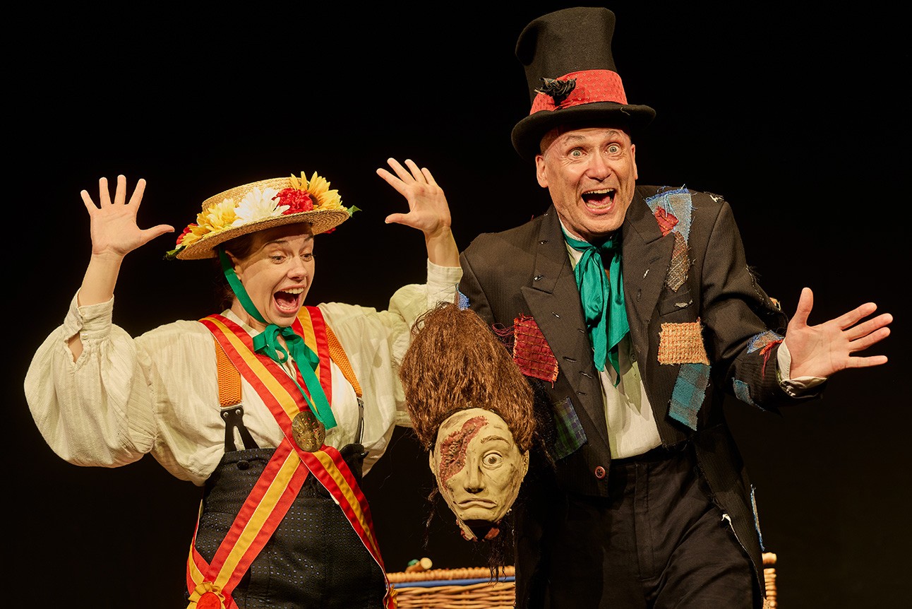 A vibrant scene from Horrible Histories: Barmy Britain featuring characters in historical costumes and props.