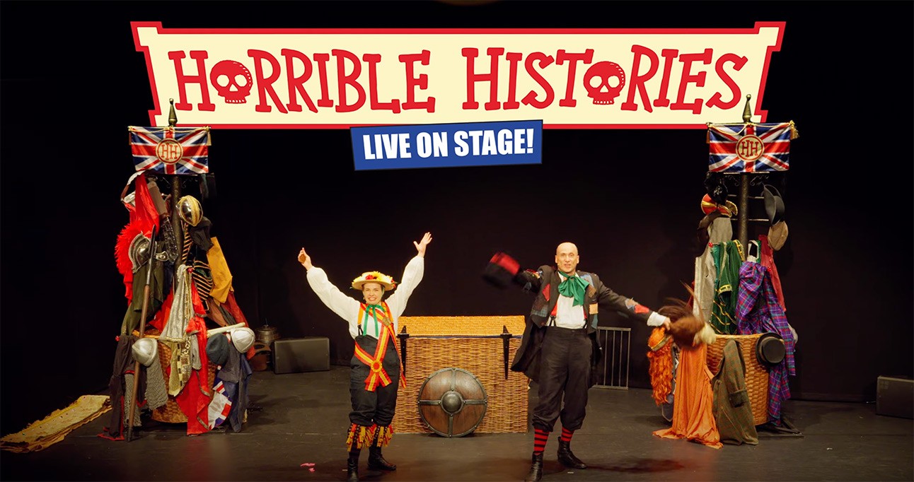 Colourful poster featuring characters from Horrible Histories: Barmy Britain with playful expressions and historical costumes.