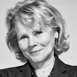 Imelda Staunton portraying a character in a theatrical performance, wearing a vintage dress and hat.