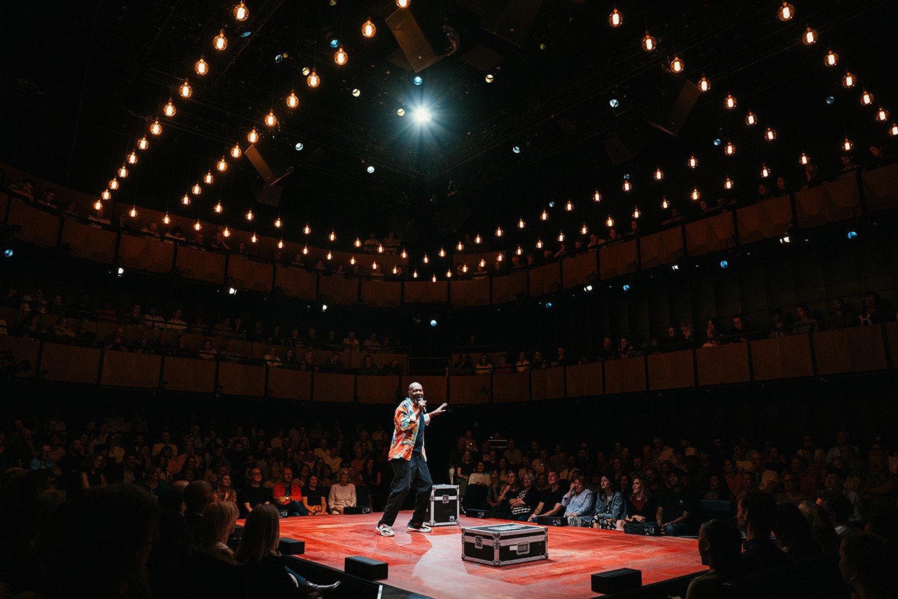 Lenny Henry performing on stage at Soho Place, with vibrant lighting and an engaged audience.