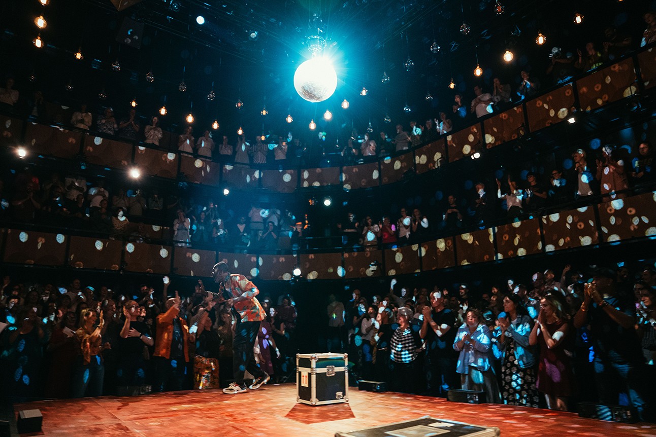 Lenny Henry performing on stage at Soho Place, with vibrant lighting and an engaged audience.