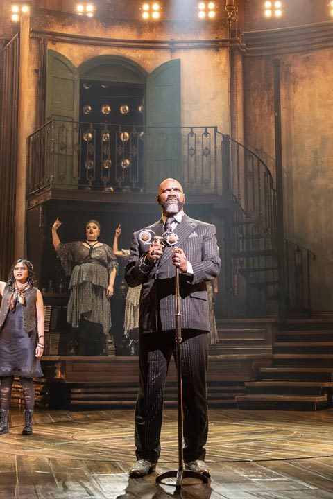 Promotional artwork for Hadestown featuring stylised illustrations of characters and a dramatic background.