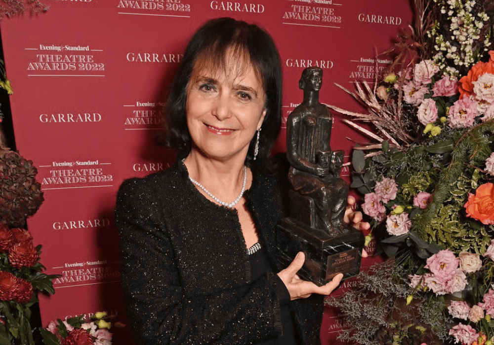 Nica Evening Standard Award trophy displayed on a wooden surface with a blurred background.