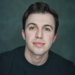 Joe with a friendly smile, wearing a blue shirt, against a neutral background.