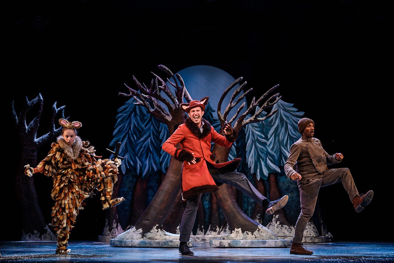 The Gruffalo's Child standing in a snowy forest, looking curiously at a distant figure.