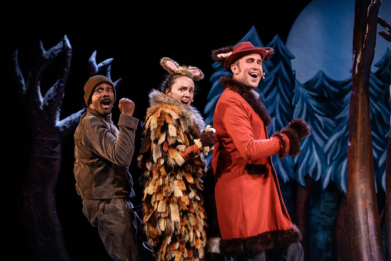 The Gruffalo's Child stands in a snowy forest, surrounded by tall trees and soft snowflakes.