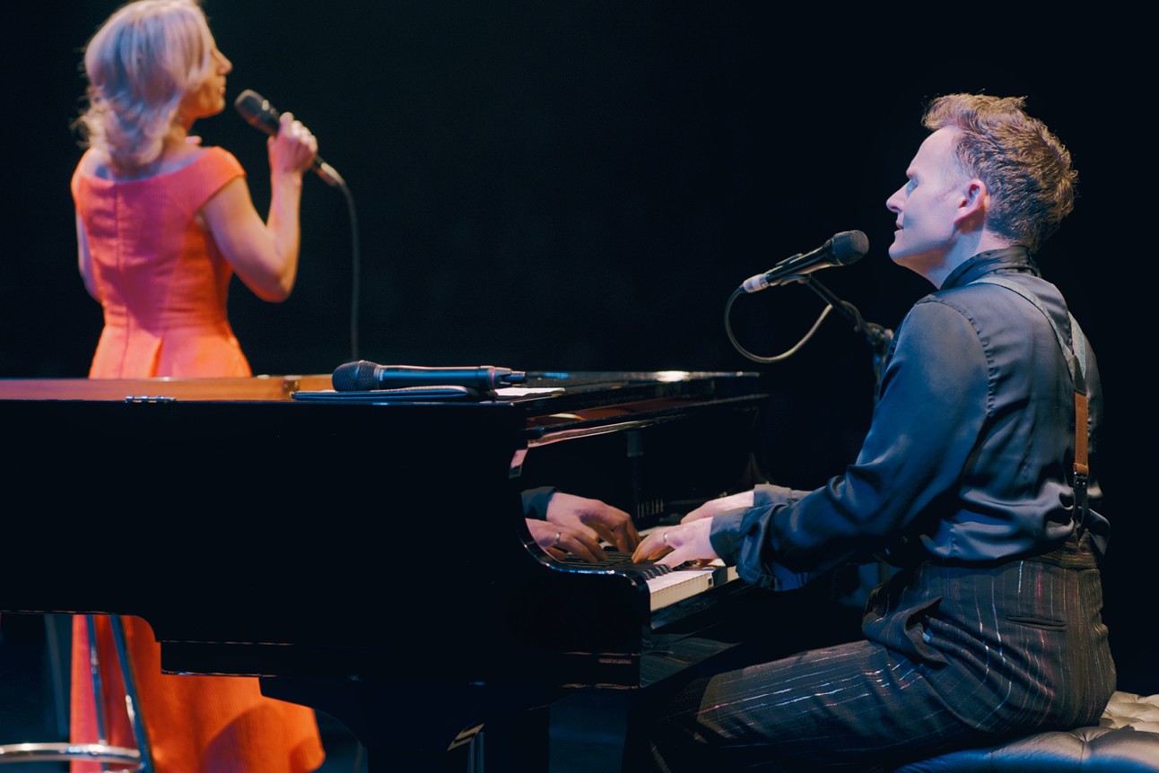 Liza Pulman and Joe Stilgoe performing on stage, with vibrant lighting and an enthusiastic audience.