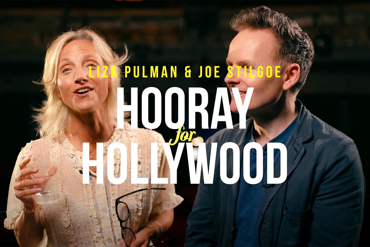 Liza Pulman and Joe Stilgoe smiling, surrounded by Hollywood-themed decorations and vibrant colours.