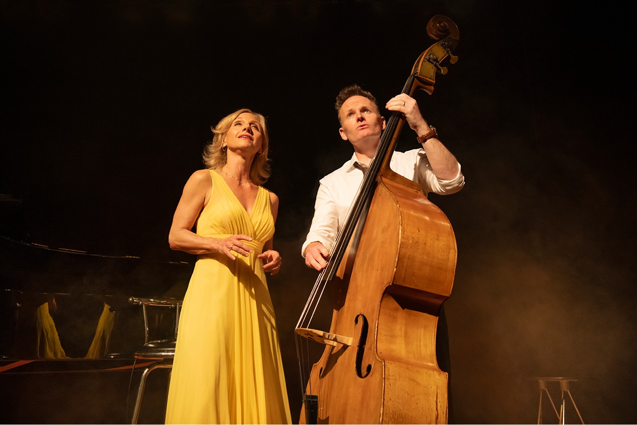 Liza Pulman and Joe Stilgoe performing on stage with vibrant lighting and a cheering audience.
