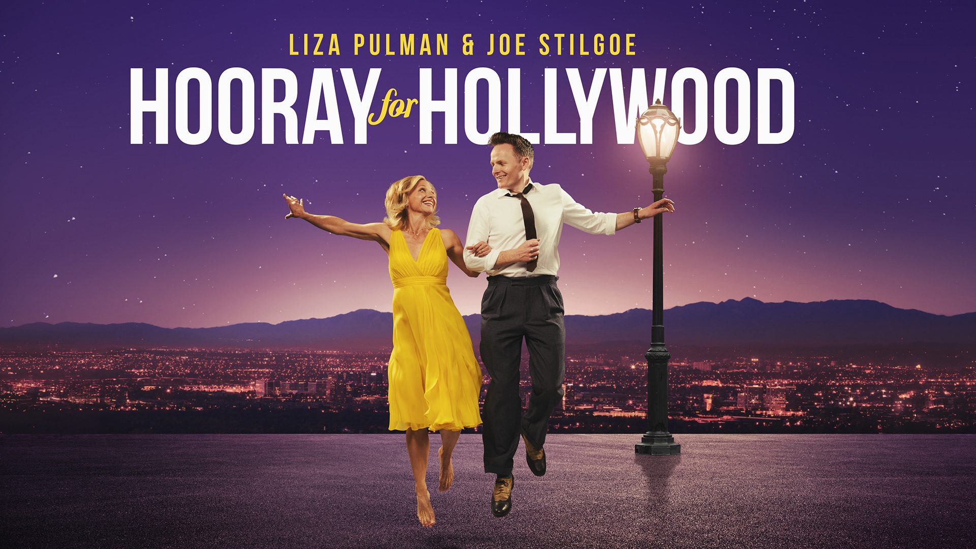 Liza Pulman and Joe Stilgoe performing on stage with vibrant lighting and a cheering audience.