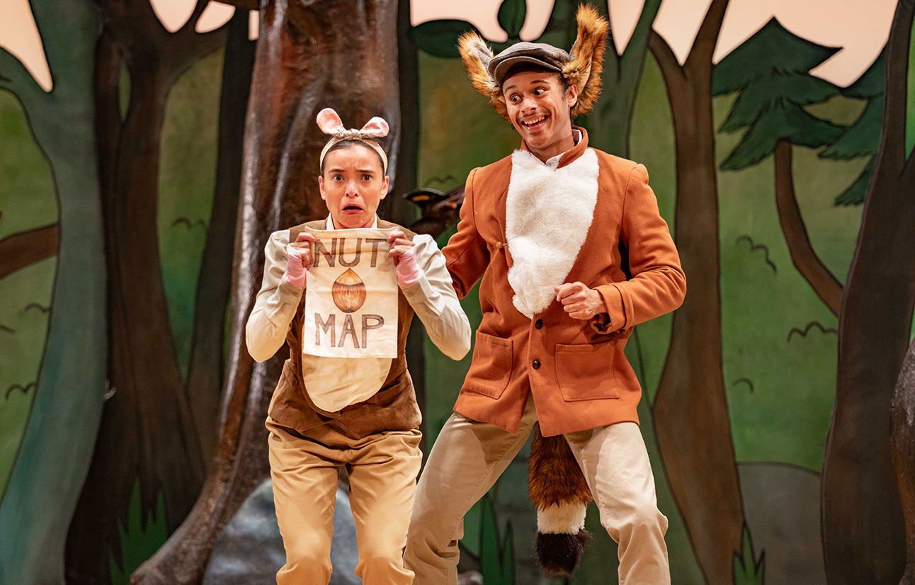 Two actors in The Gruffalo costumes, one holding a map, performing on a forest-themed stage.