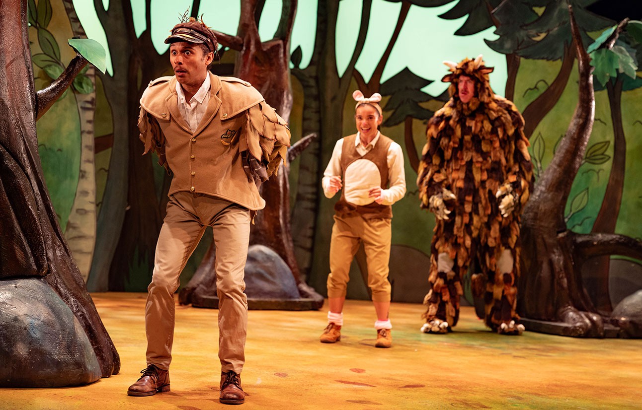 Actors in colourful costumes perform on stage with a dark forest backdrop from The Gruffalo 2024.