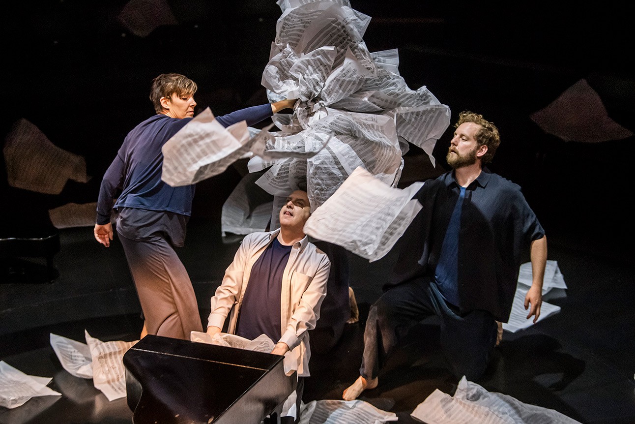 Phelim McDermott, Sarah Wright, and David Emmings perform with large paper sculpture in theatrical setting.